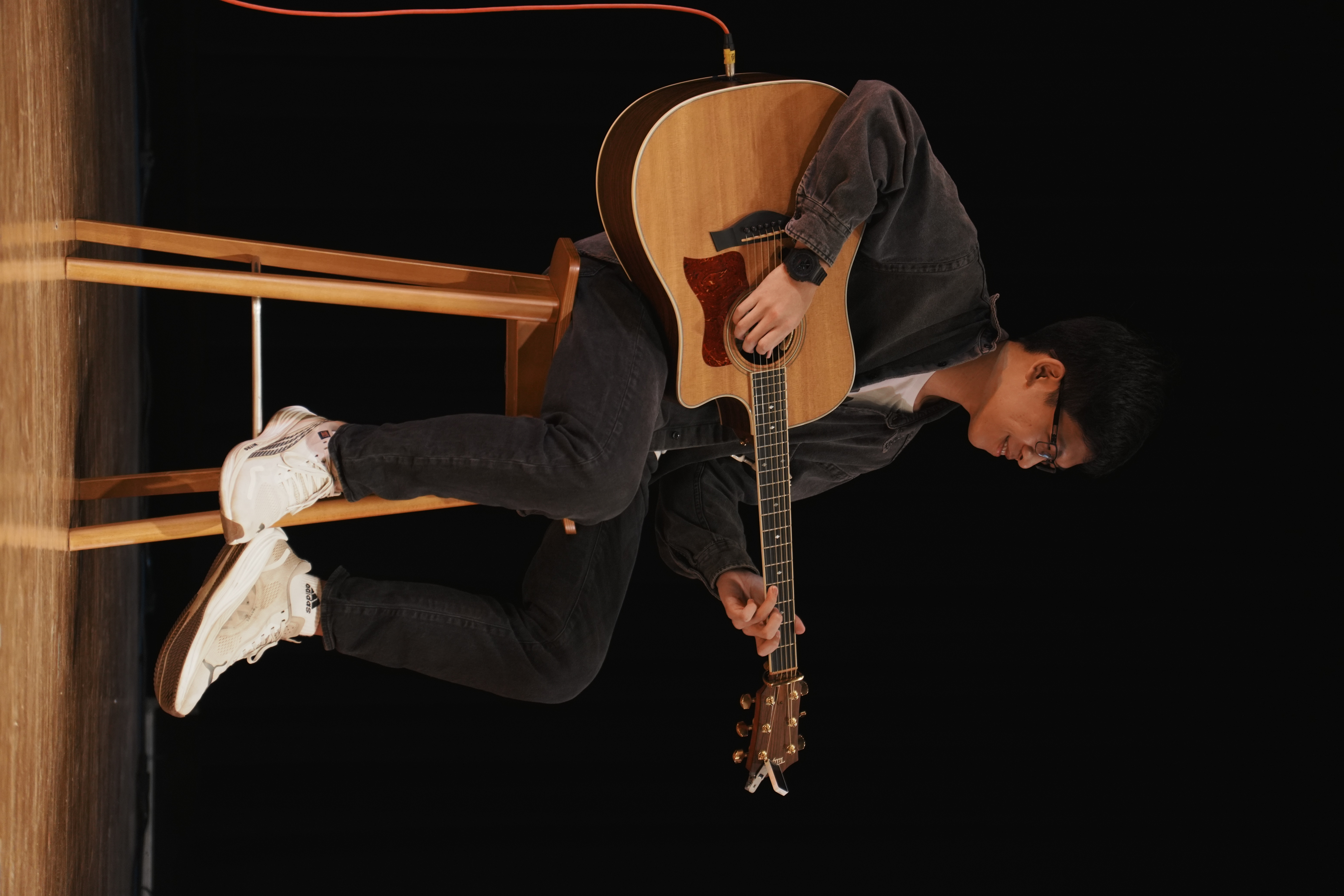 Jasper playing acoustic guitar on stage